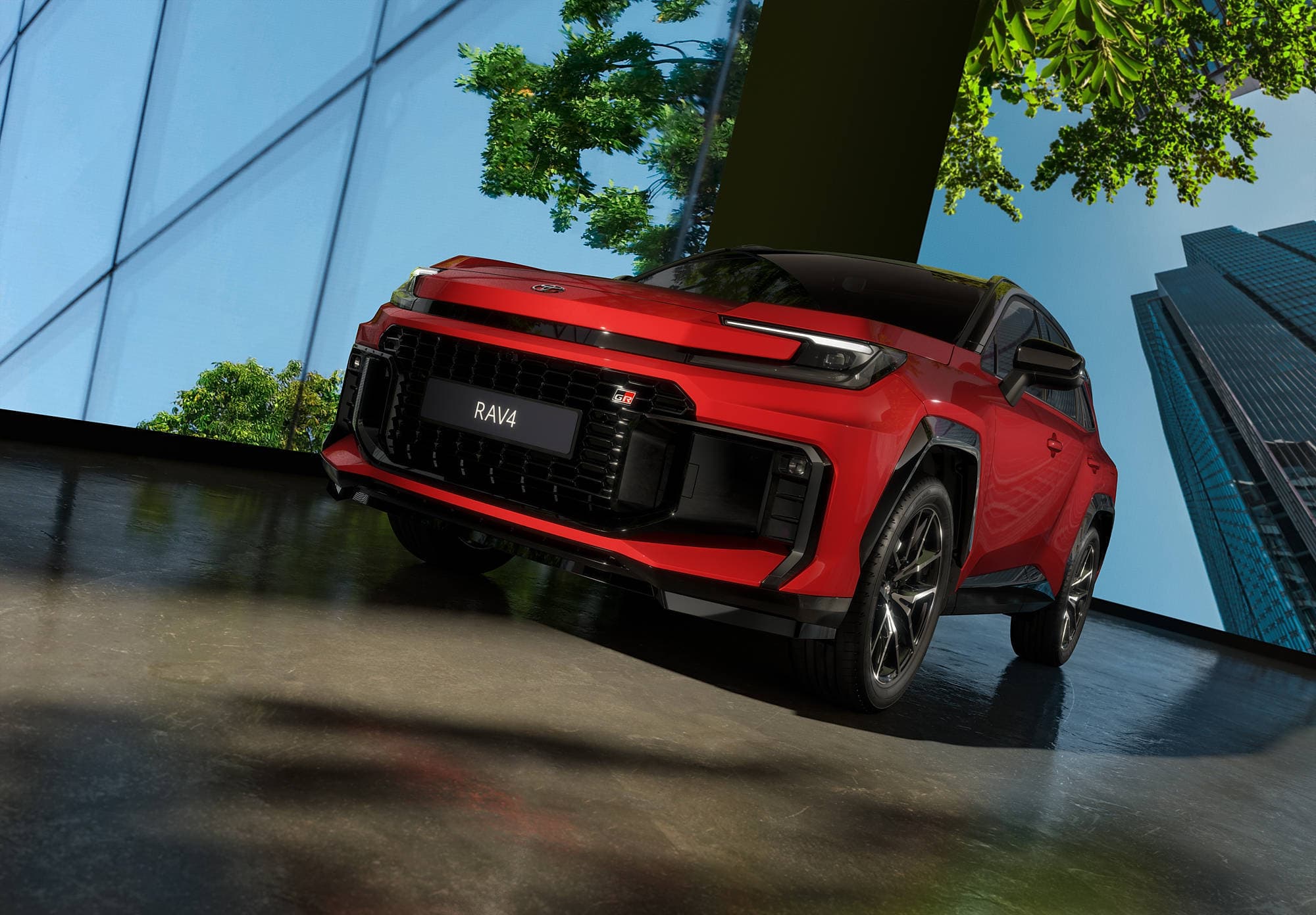 Red Toyota RAV4 parked indoors, viewed from a low angle with a modern glass building and green foliage in the background.
